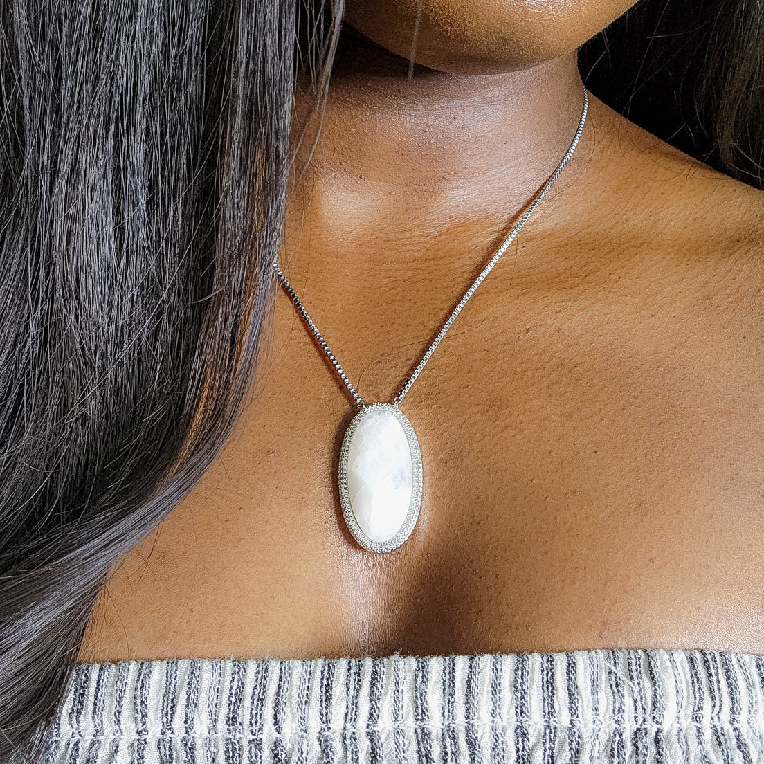 Moonstone silver necklace with a large pendant worn by a person